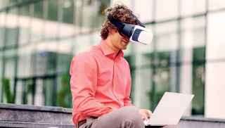 Man with virtual headset on laptop