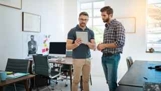 Two men standing in an office talking