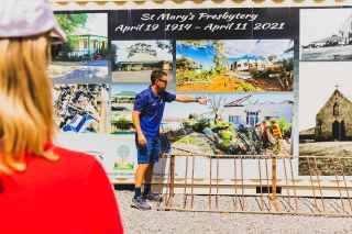 A man in a blue shirt Explains how the funds had been used towards rebuilding the community