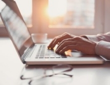 Hands typing on laptop