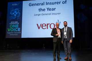 Two men in suits on stage holding award, Vero wins General Insurer of the Year at 2019 NIBA Convention.