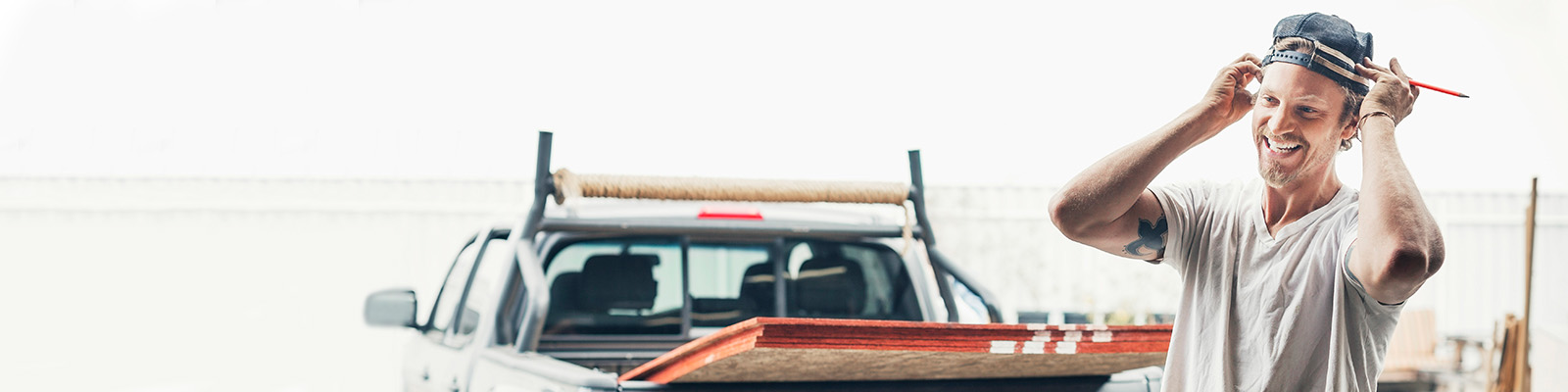 Builder smiling in front of work ute