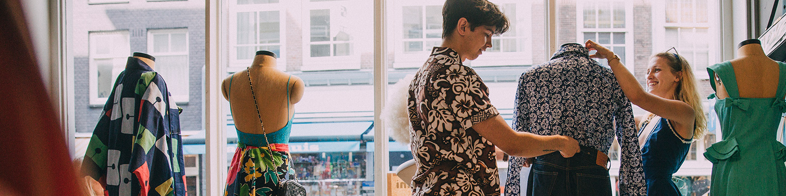 Woman and man styling dress mannequins