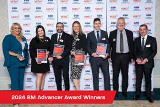 A group of people holding awards in front of branded backdrop; red banner reads &#34;2024 RM Advancer Award Winners